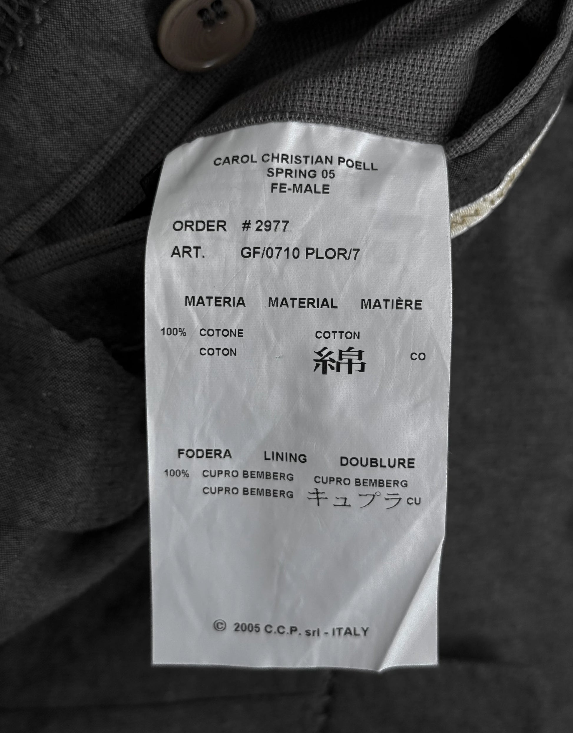 Clothing label on a garment with text and material details.