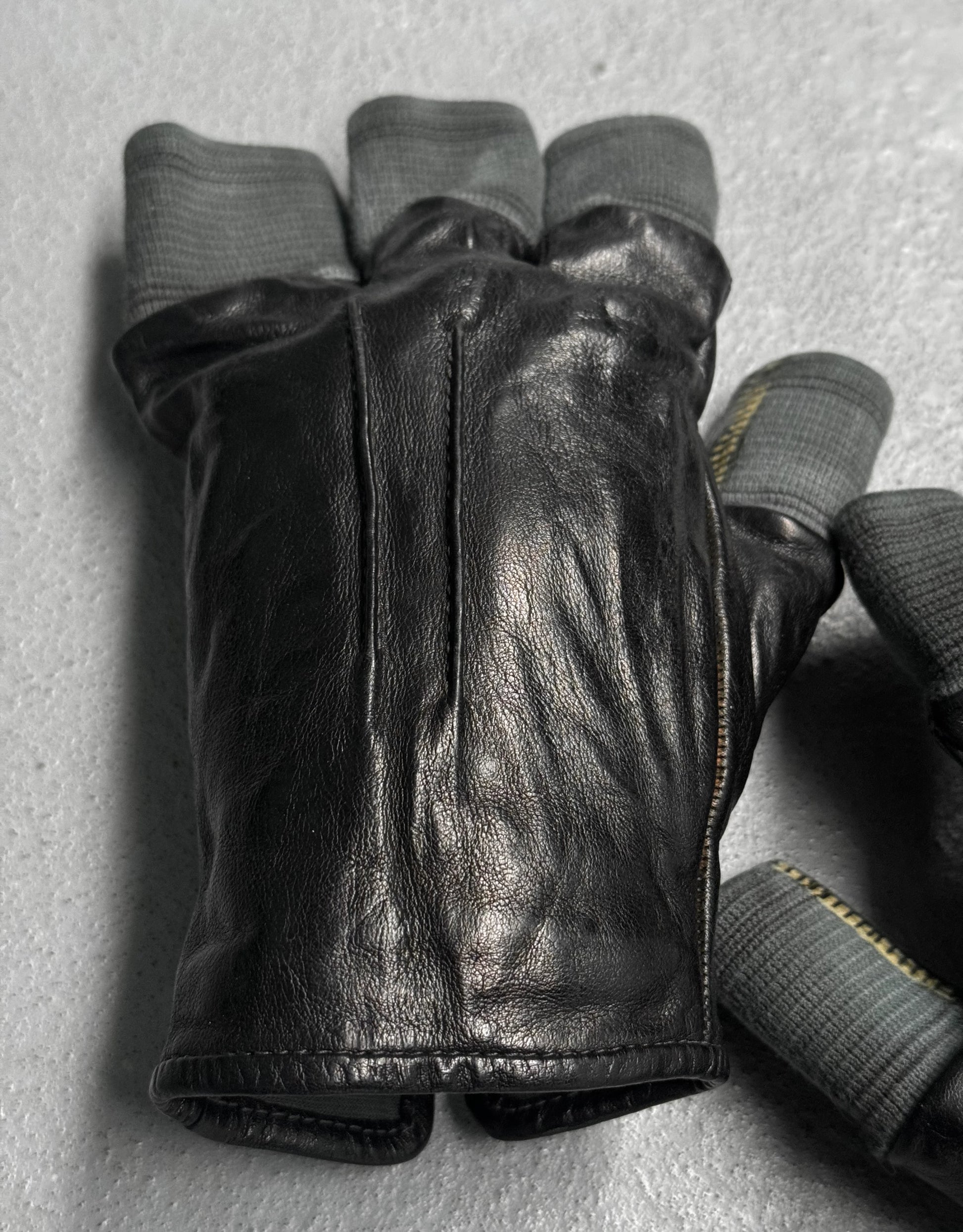 Black leather glove with gray lining on a light gray background