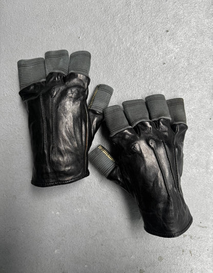 Pair of black leather gloves with gray fingertips on a gray surface