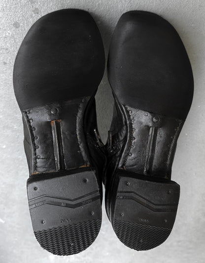 Pair of black leather shoes on a gray surface