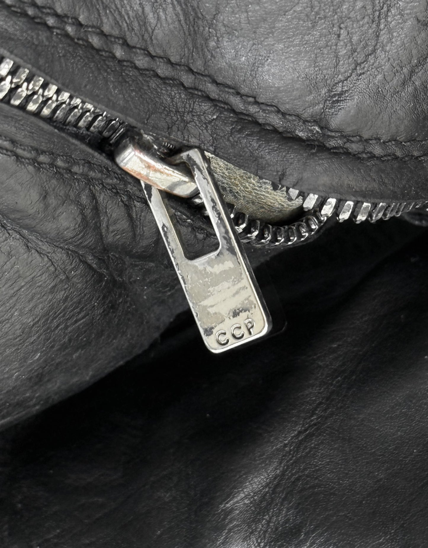 Close-up of a zipper on a black leather surface