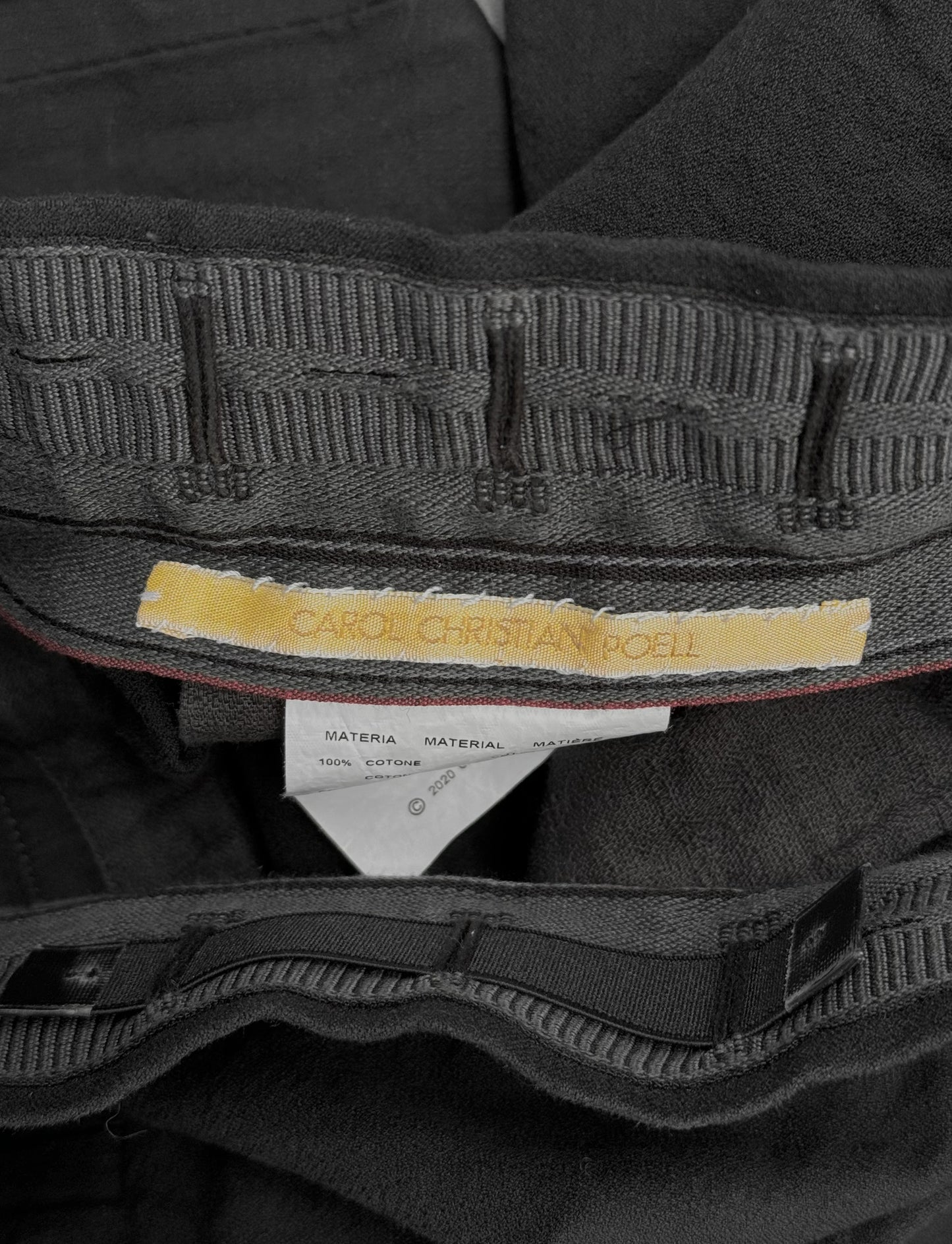 Close-up of a black garment with a visible label on a dark background