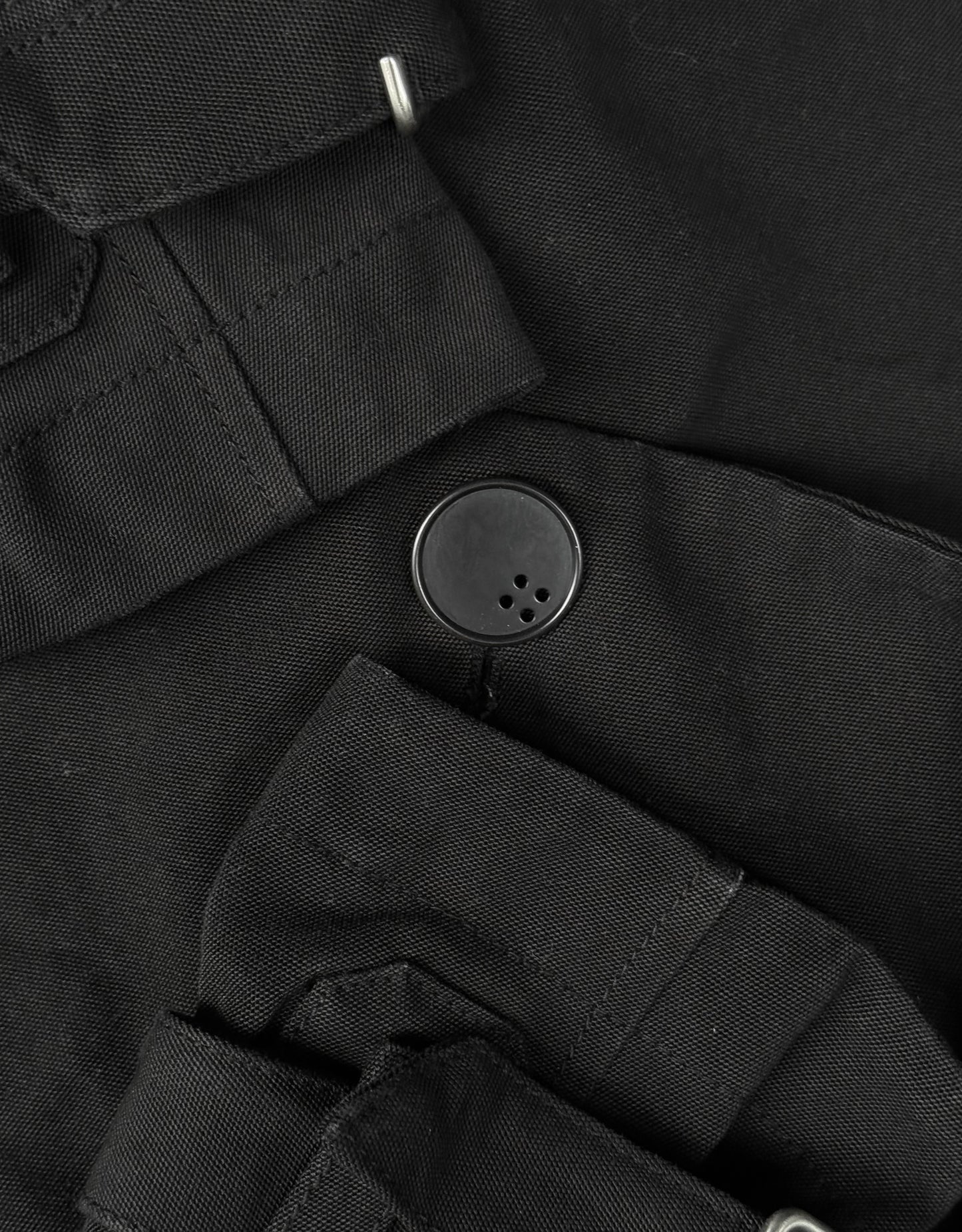 Close-up of a black button on a black fabric background