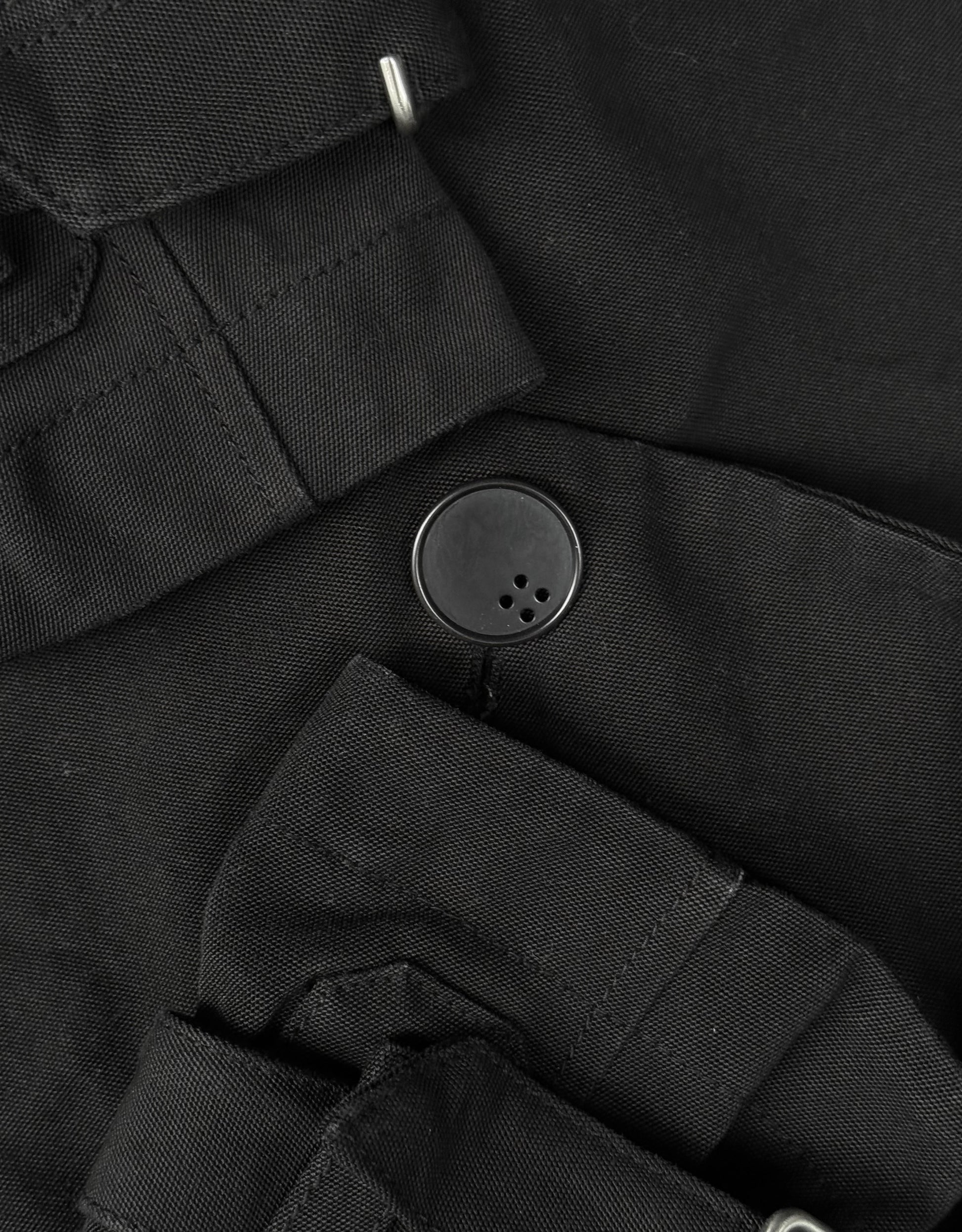 Close-up of a black button on a black fabric background