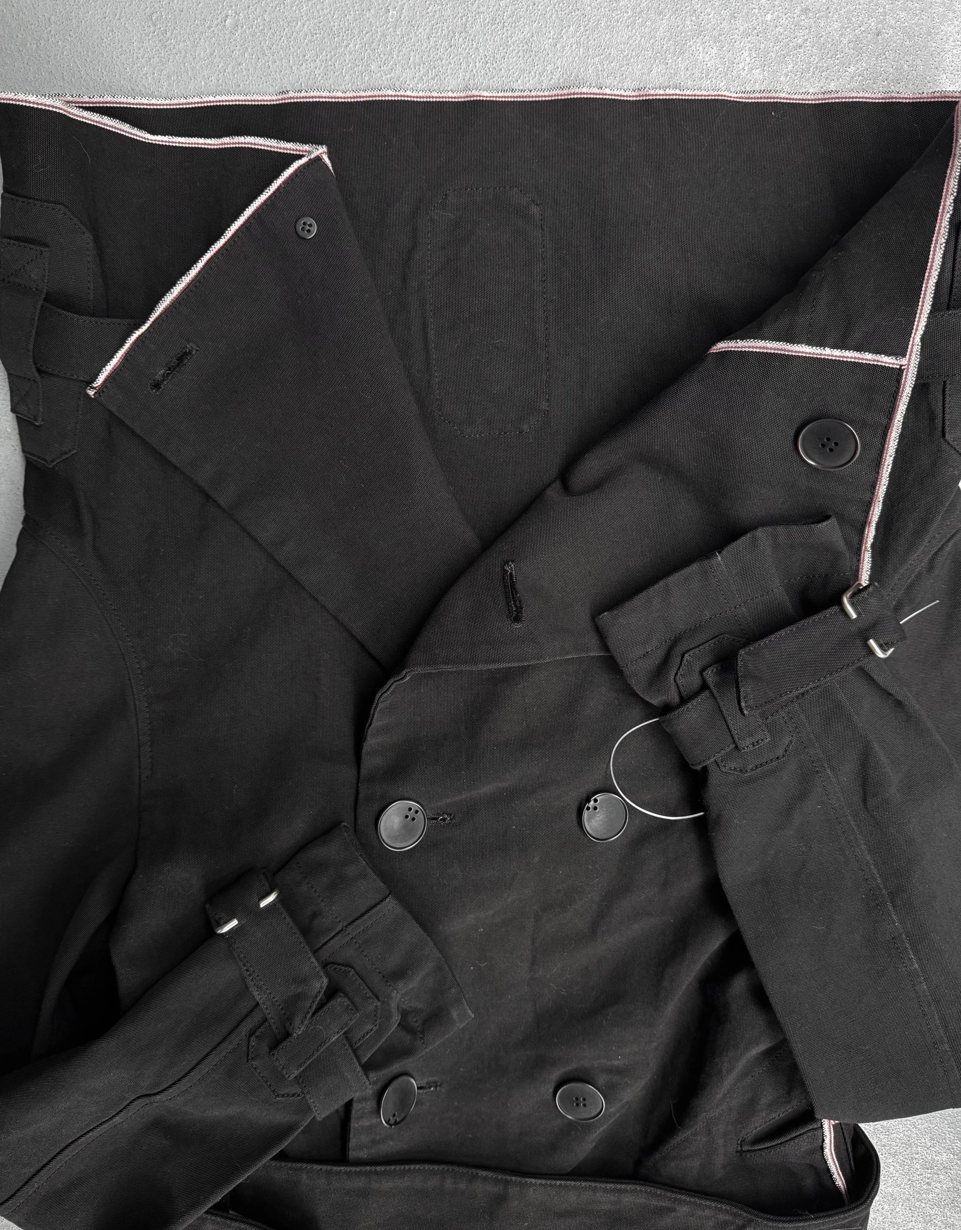 Close-up of a black coat with buttons on a light gray background