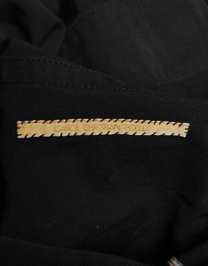 Close-up of a black garment with a gold label on a dark background
