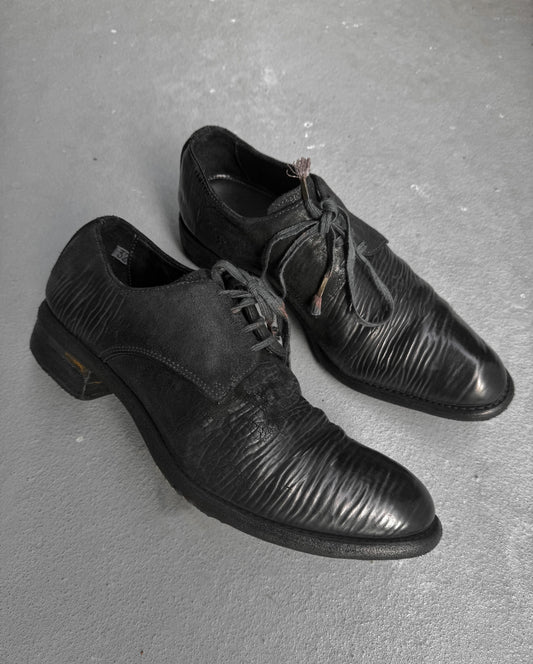 Pair of black dress shoes on a gray surface