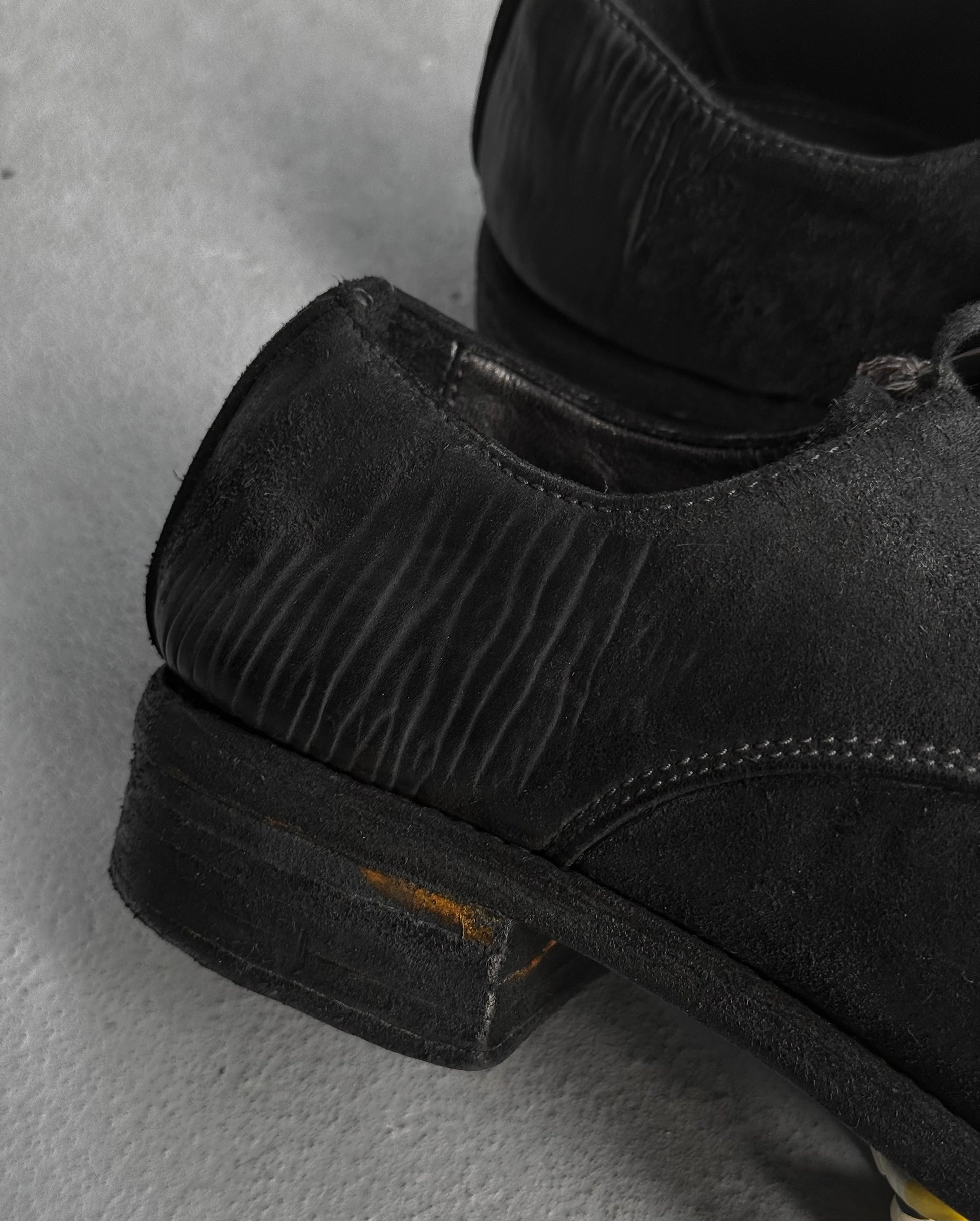 Close-up of black leather shoes on a gray surface