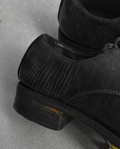 Close-up of black leather shoes on a gray surface