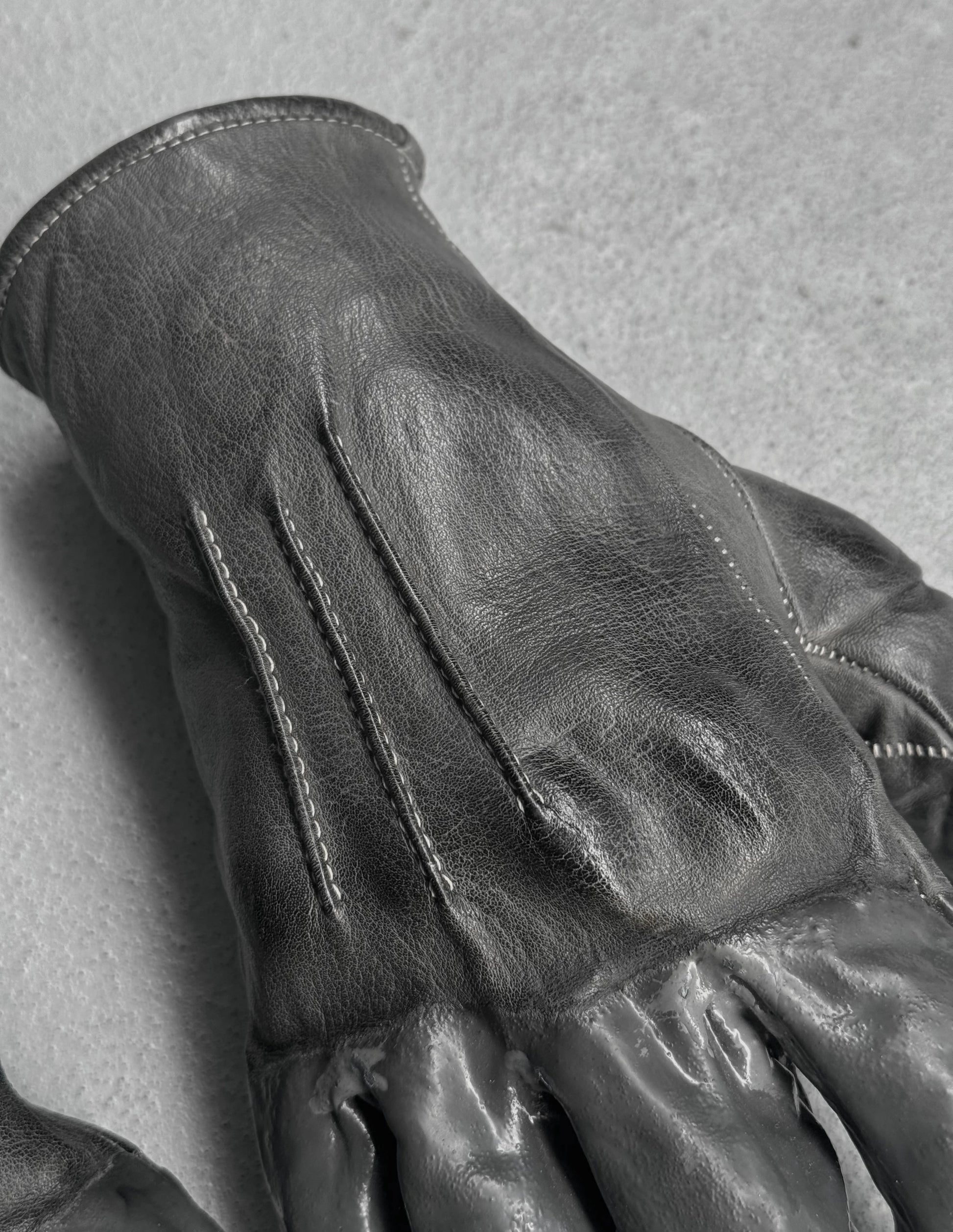 Close-up of a black leather glove on a gray background