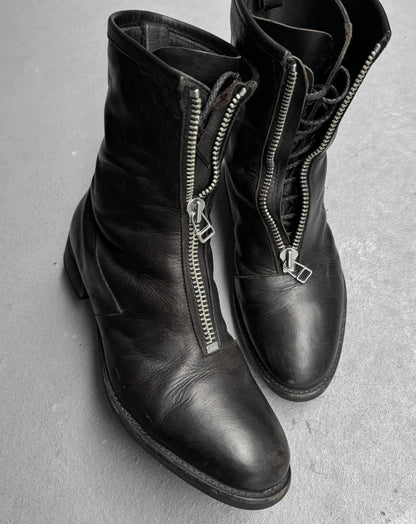 Black leather boots with zippers on a gray surface