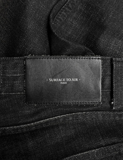 Close-up of a black leather label stitched onto the Surface To Air SS14 Faded Black Bootcut Skinny Denim, featuring the brands name and reflecting its contemporary urban menswear style.