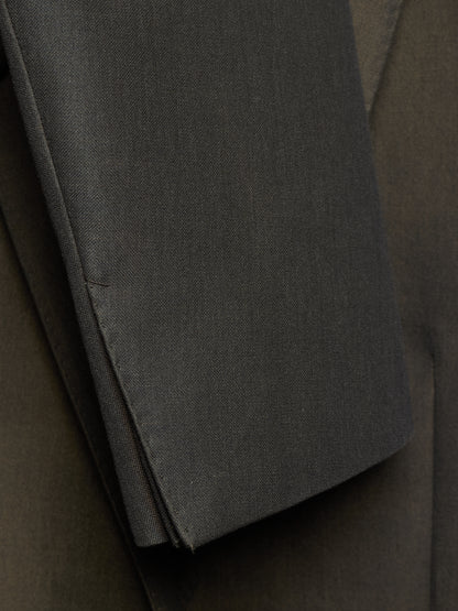 Close-up of a dark charcoal gray fabric sleeve or folded garment detail, showing the texture and stitching against a matching dark background.