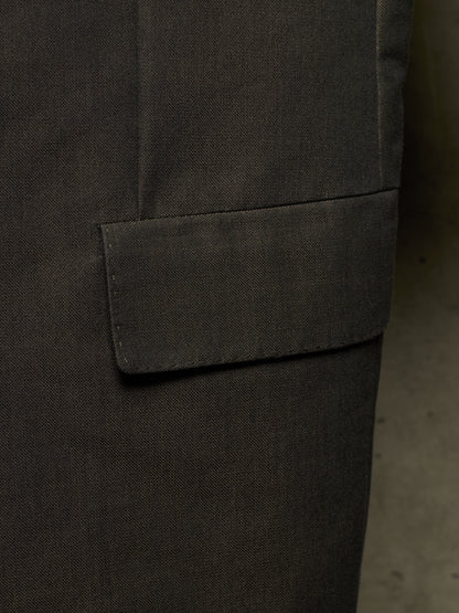 Close-up detail of a dark charcoal gray fabric garment, showing a pocket flap and textured woven material.