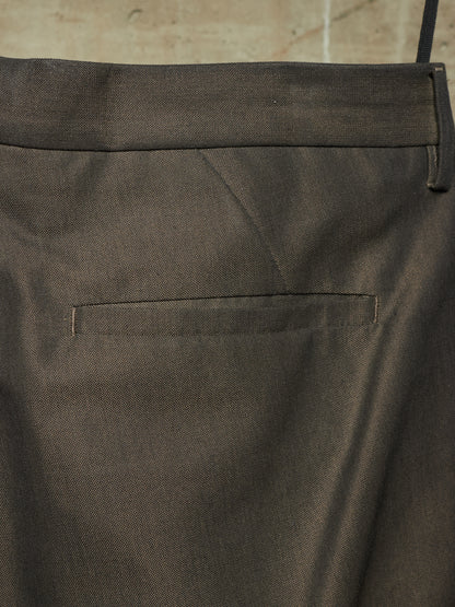 Close-up of the back waistband and pocket of dark charcoal gray trousers, showing the fabric texture and stitching.