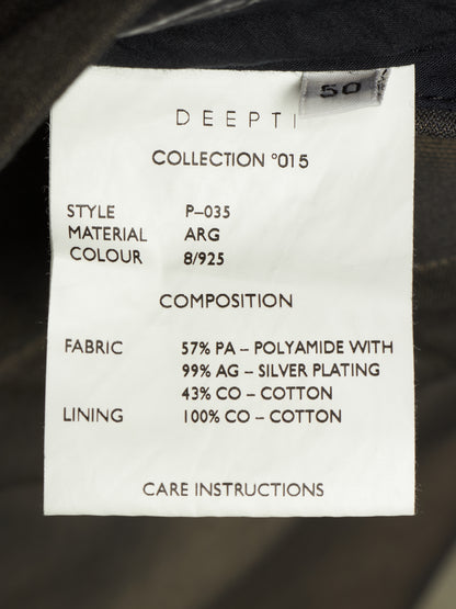 A close-up of a white fabric care label showing product details including 'DEEPTI', 'COLLECTION 015', 'STYLE P-035', 'MATERIAL COLOUR ARG 8/925', and composition/fabric/lining information, photographed against dark clothing fabric.