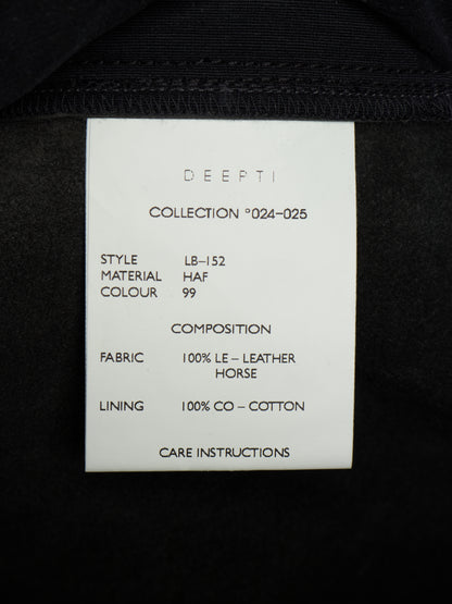 A white paper size and care label from the brand DEEPTI, showing details for collection '024-025' style LB-152, placed on the inside of a black garment.