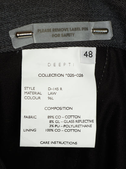 Close-up of a garment interior label reading DDEPTI, with size 48 and fabric details on a black fabric background.