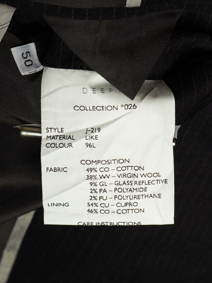 Close-up of a garment's interior label showing details such as style J-219, material composition, and fabric details, with a small size tag reading 50.