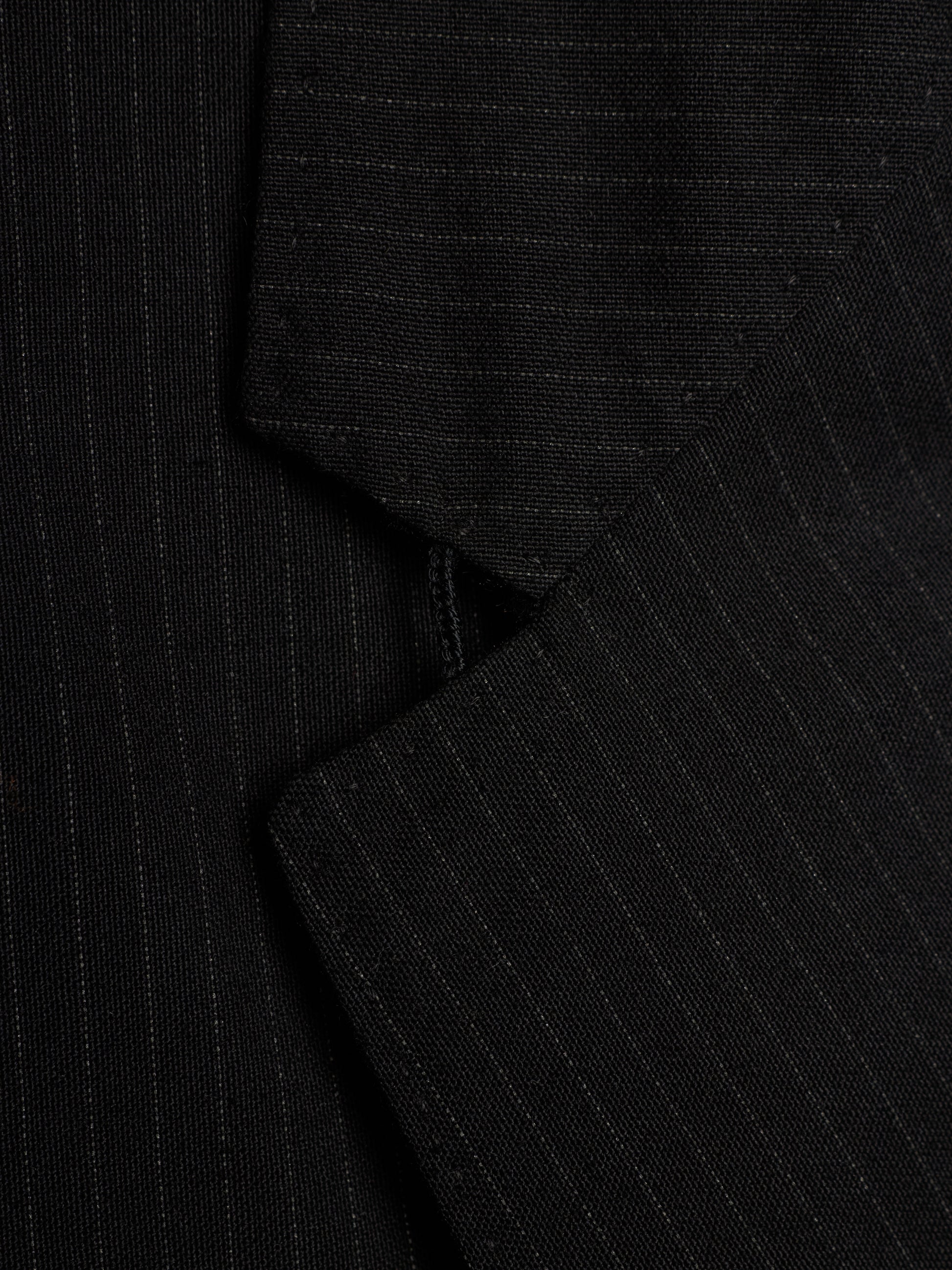 Close-up of a black pinstriped fabric, showing the fine vertical stripe pattern and texture.