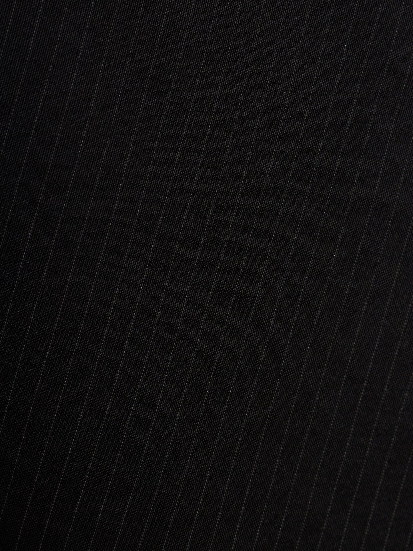 Close-up of a black fabric with thin vertical white pinstripes.