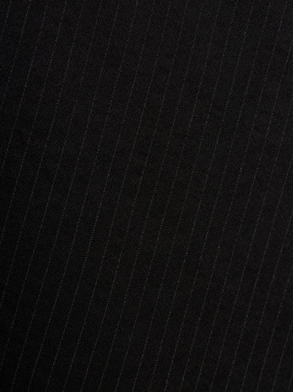 Close-up of a black fabric with thin vertical white pinstripes.