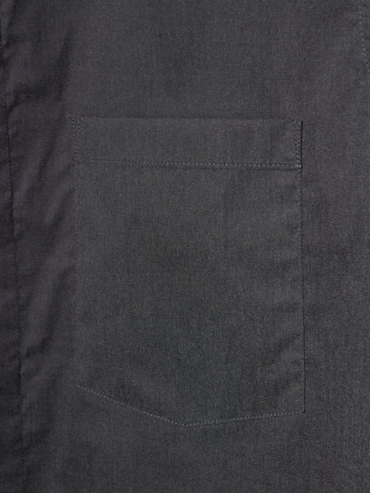 Close-up of a dark charcoal gray fabric garment showing a single rectangular chest pocket with neat stitching.