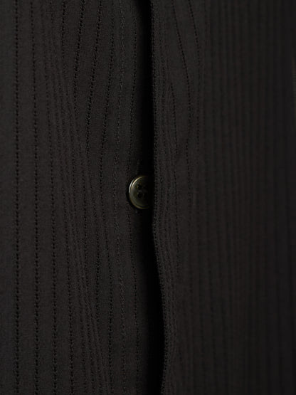 Close-up of a black ribbed knit button-up shirt showing the vertical texture and a single button.
