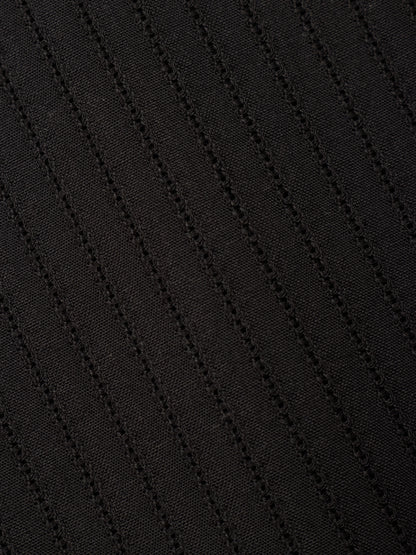 Close-up of a black textured fabric with diagonal ribbed or waffle-like stitching.
