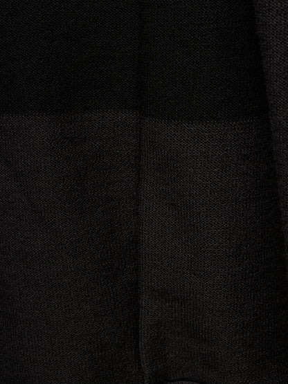 Close-up of a black textured fabric with a subtle woven pattern and a vertical seam.