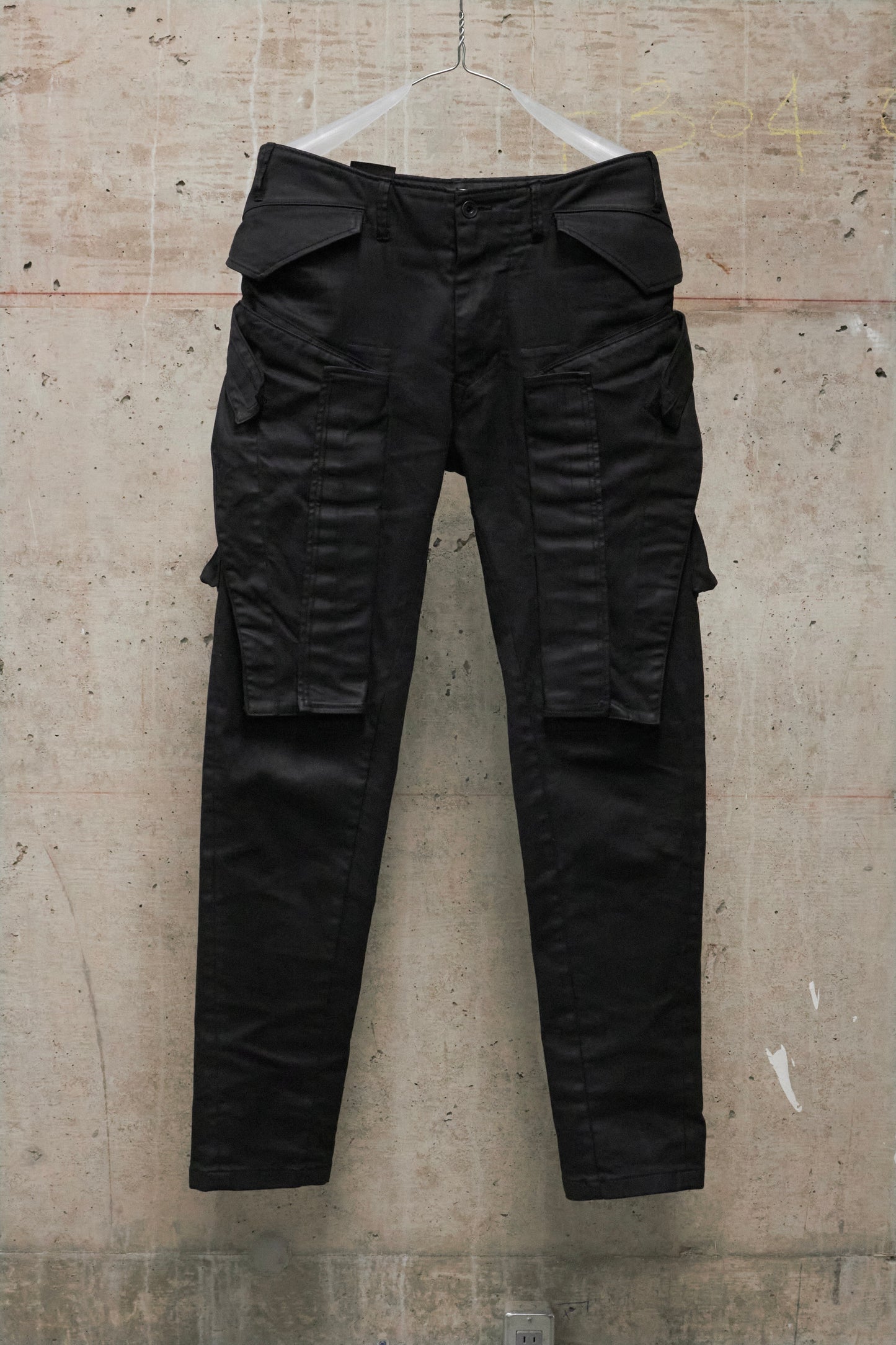 Black cargo pants on a textured beige background