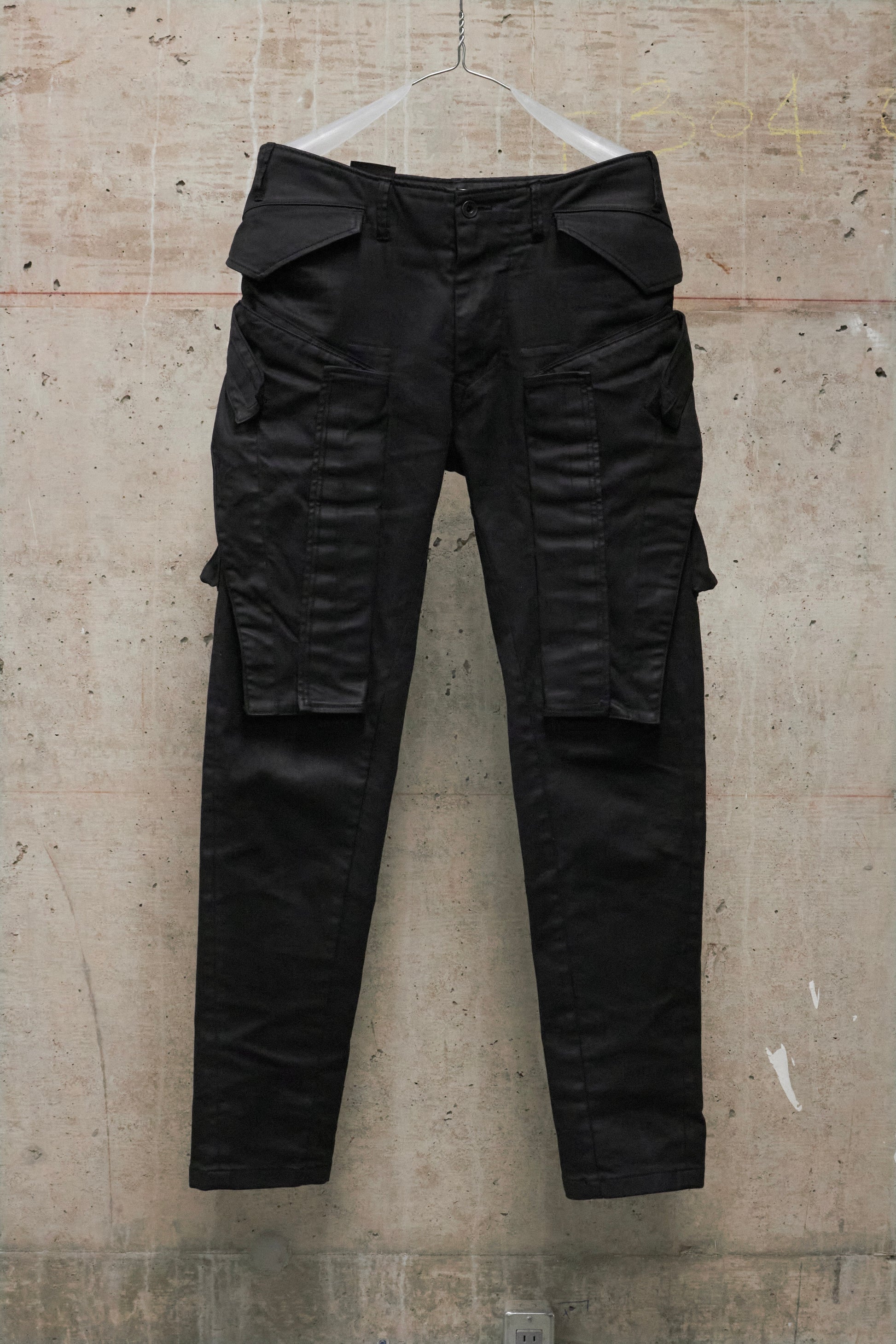 Black cargo pants on a textured beige background
