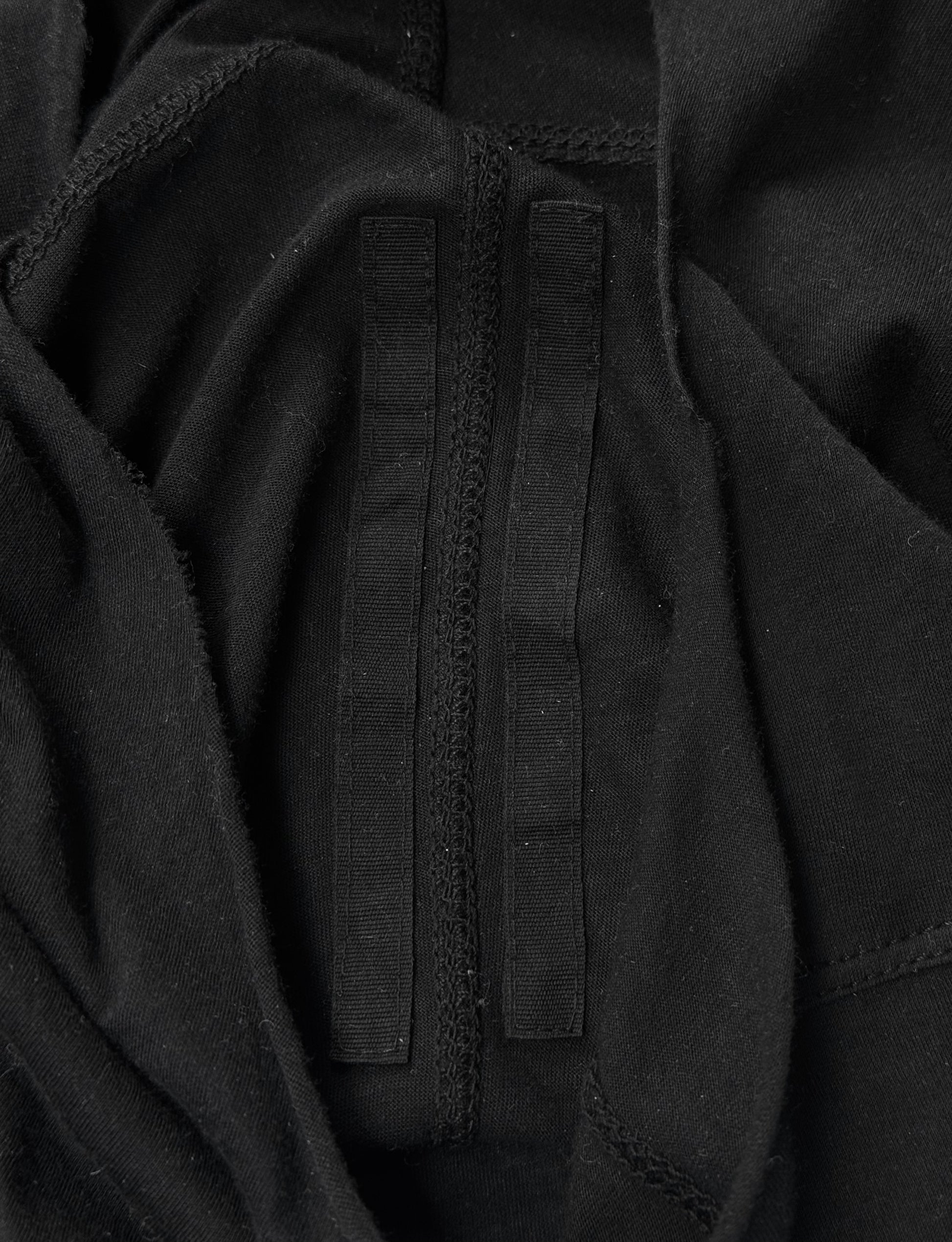 A close-up of black fabric with two parallel black velcro strips, inspired by Rick Owens DRKSHDW AW24 “PORTERVILLE” Geometric Level Long-sleeves, nodding to the brand’s iconic avant-garde aesthetic.