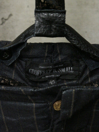 Close-up of a black jacket with a 'Geoffrey B. Small' label on a textured background