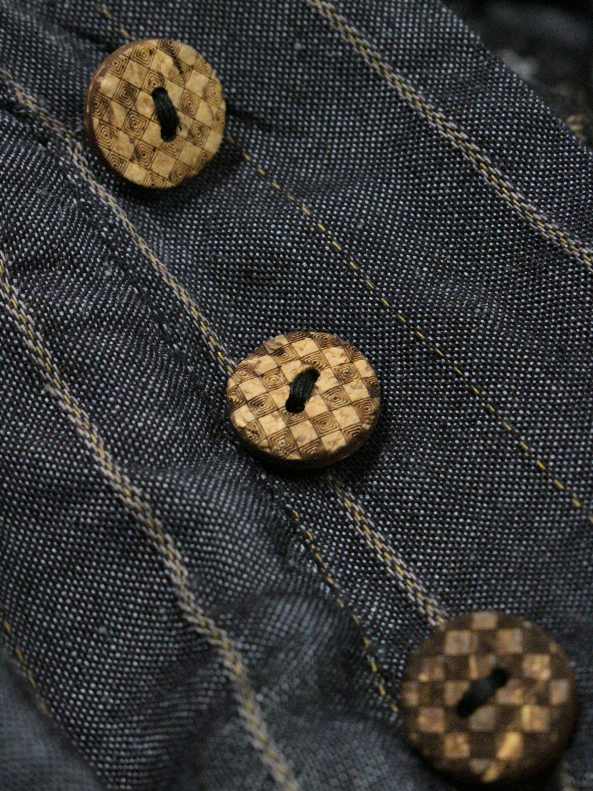 Close-up of denim fabric with brown buttons