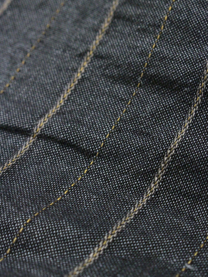 Close-up of dark denim fabric with visible stitching