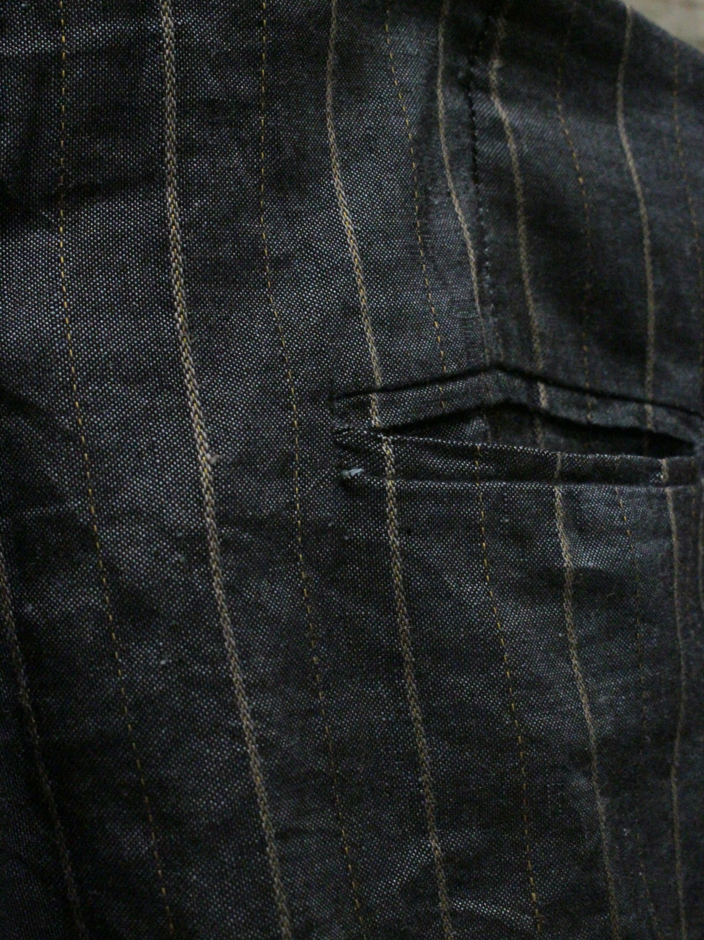 Close-up of a dark pinstripe fabric with a pocket detail