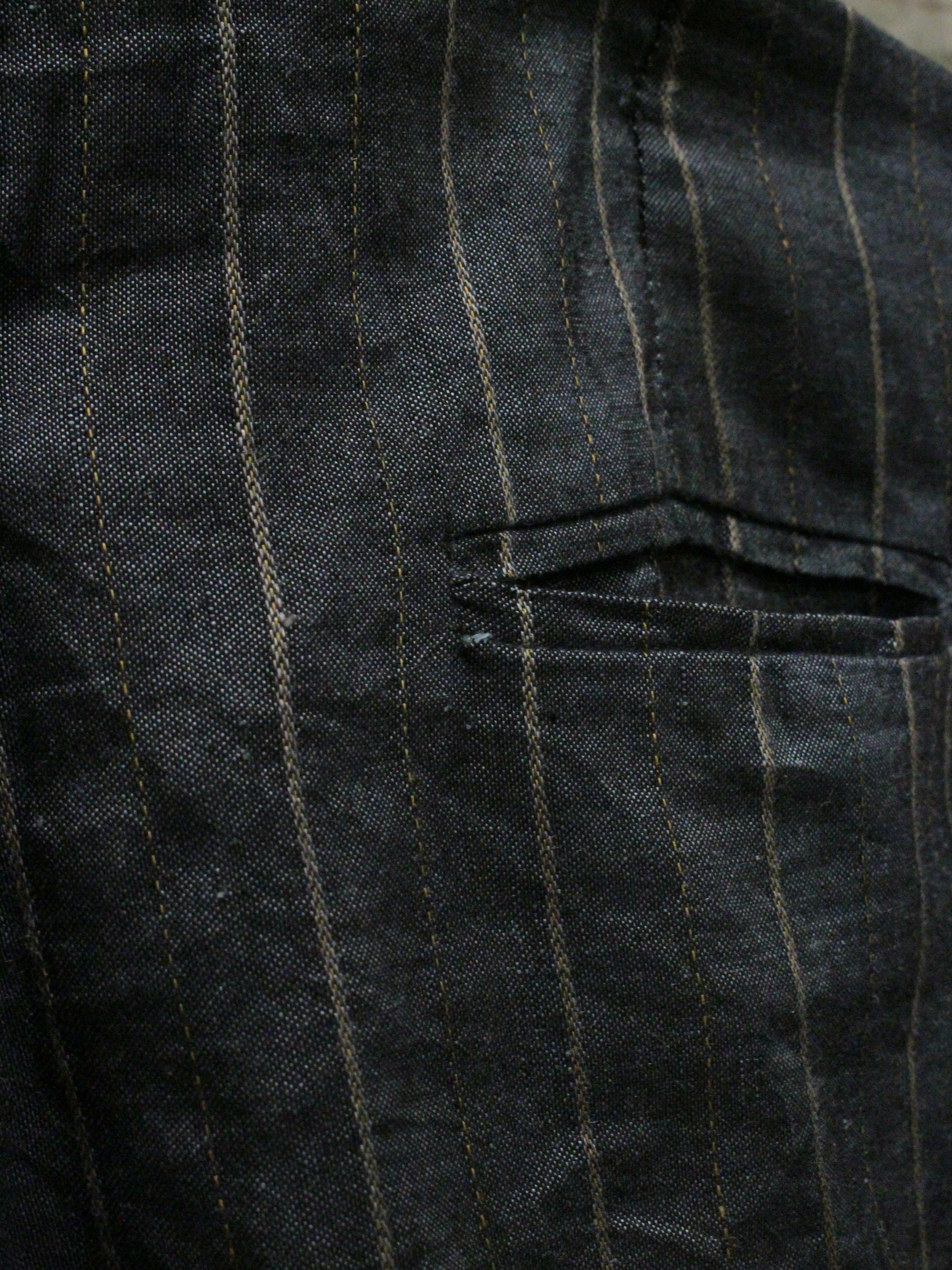 Close-up of a dark pinstripe fabric with a pocket detail