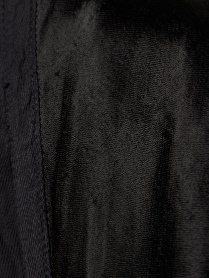 Close-up of a black textured fabric with a visible vertical seam.