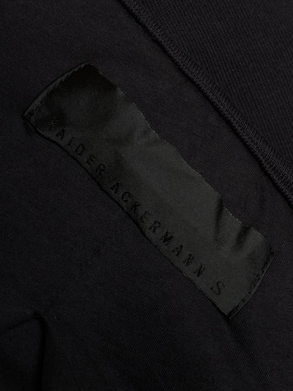 Close-up of a black garment showing a satin brand label that reads 'SALTER ACKERMANN S'.