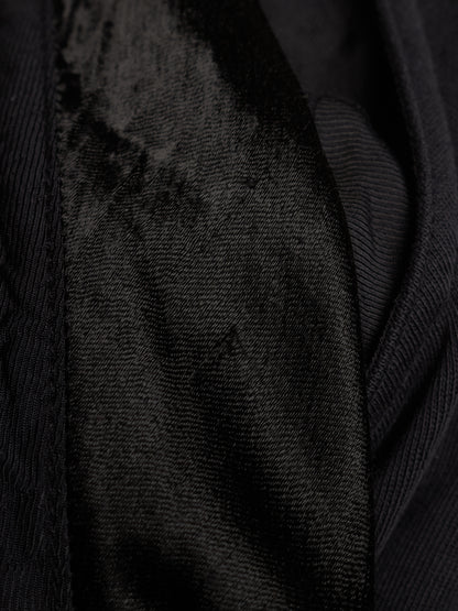 Close-up of a black textured fabric with a ribbed outer material and a plush velvet-like inner panel.