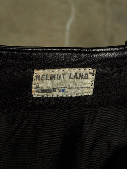 Close-up of a black garment interior showing a sewn-in label that reads HELMUT LANG and PRODUCED IN 1989.