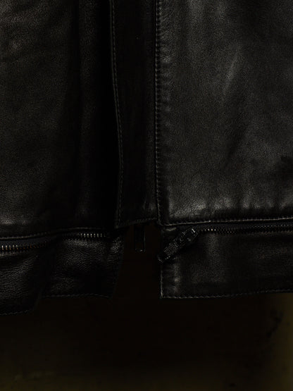 Close-up detail of a black leather jacket showing the texture, stitching, and zipper hardware.