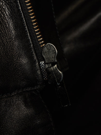 Close-up of a black leather zipper with a dark metal pull tab engraved with 'RS MADE IN ITALY'.