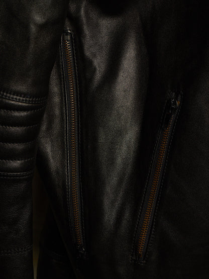 Close-up of a black leather jacket with two vertical zippered pockets and contrast stitching.