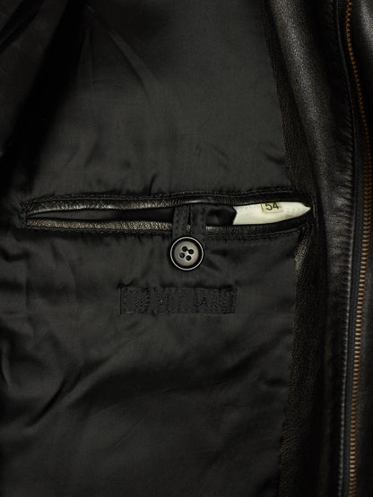 Close-up of a black leather jacket showing the interior lining, a buttoned pocket, and a zipper track.