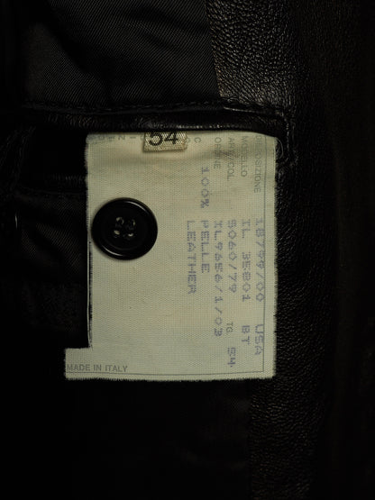 Close-up of a garment interior label sewn onto black leather or faux-leather fabric, with a black button and printed size/manufacturer text visible.