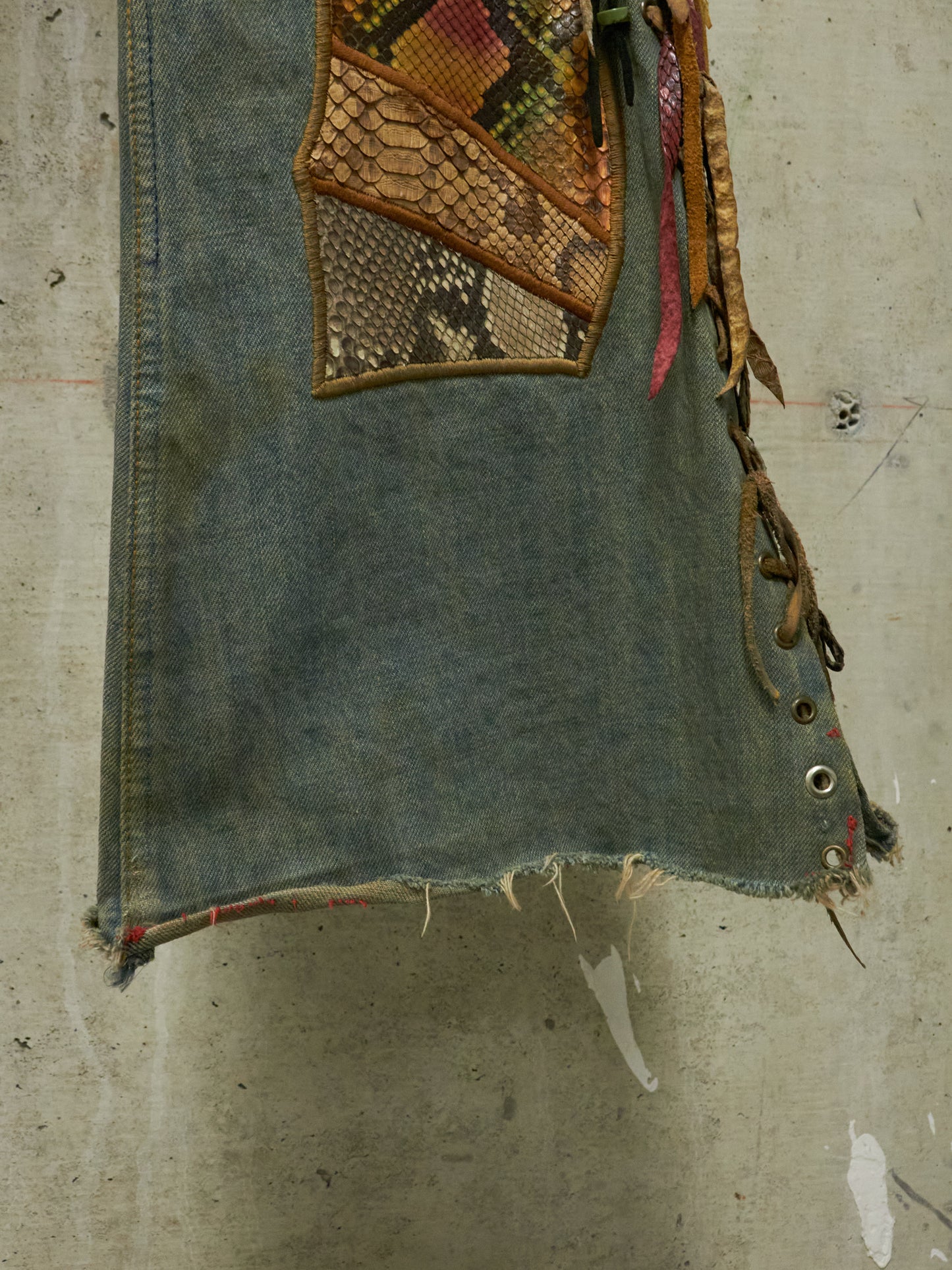 Denim vest with patchwork design on a textured surface
