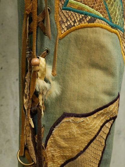 Close-up of a textured fabric with embroidered patterns and a small plush toy attached.