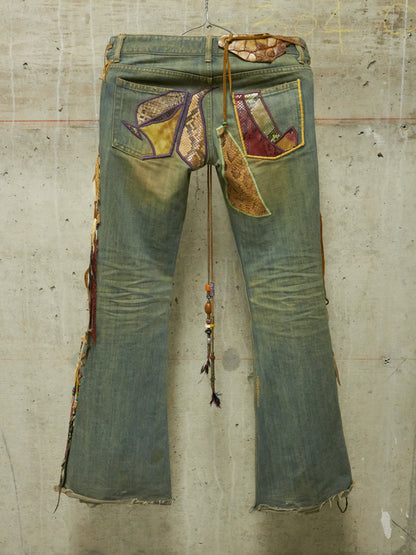 Pair of patchwork jeans on a textured concrete wall